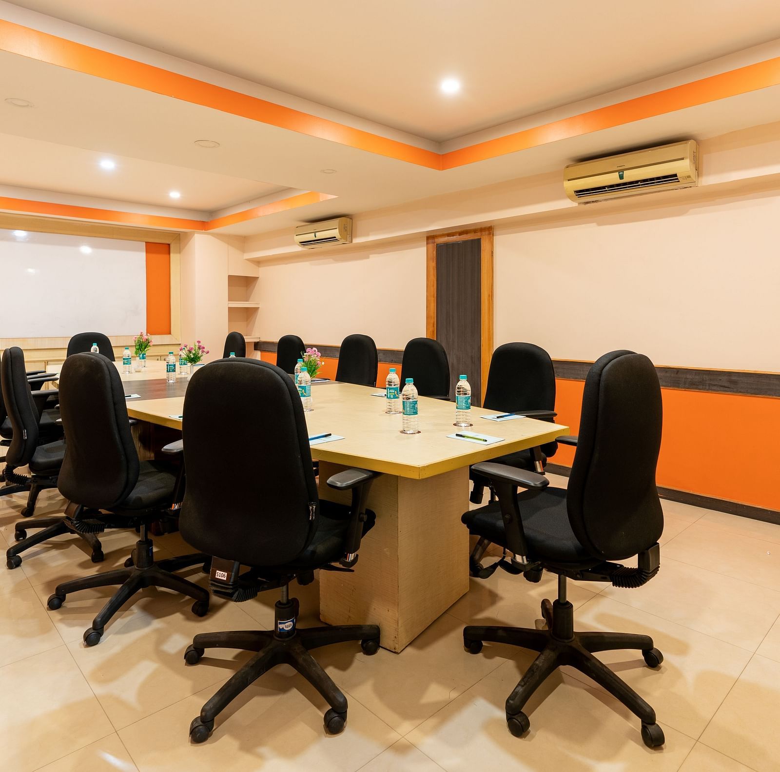 An image of a conference hall with a round table and chairs at Hotel Pai Vista, Mysore