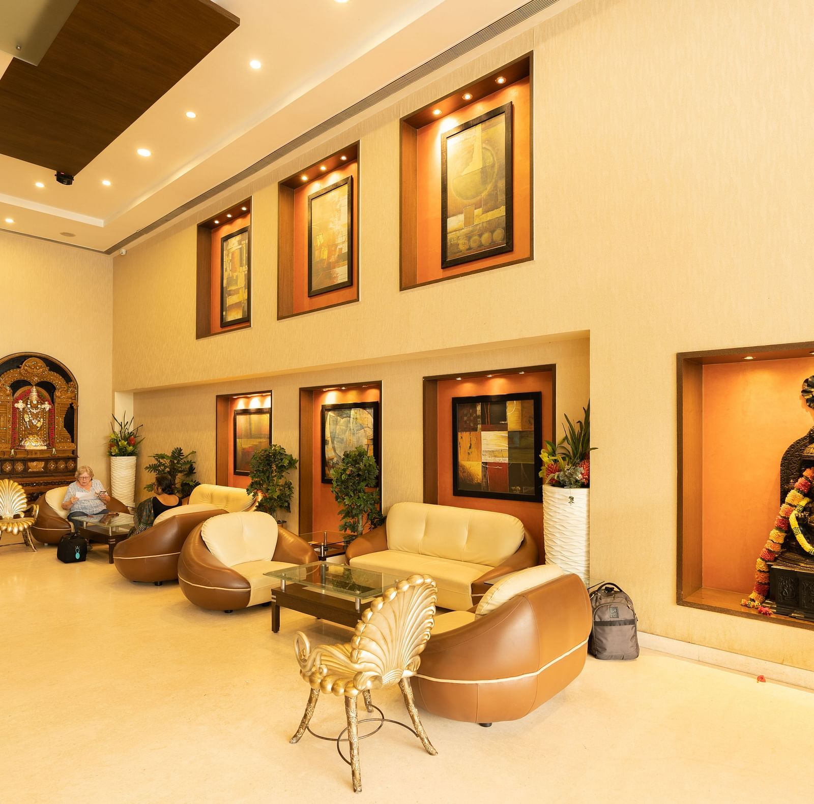 An image of a lobby featuring sofas and chairs along with painting hanged on the wall - Hotel Pai Vista, Mysore