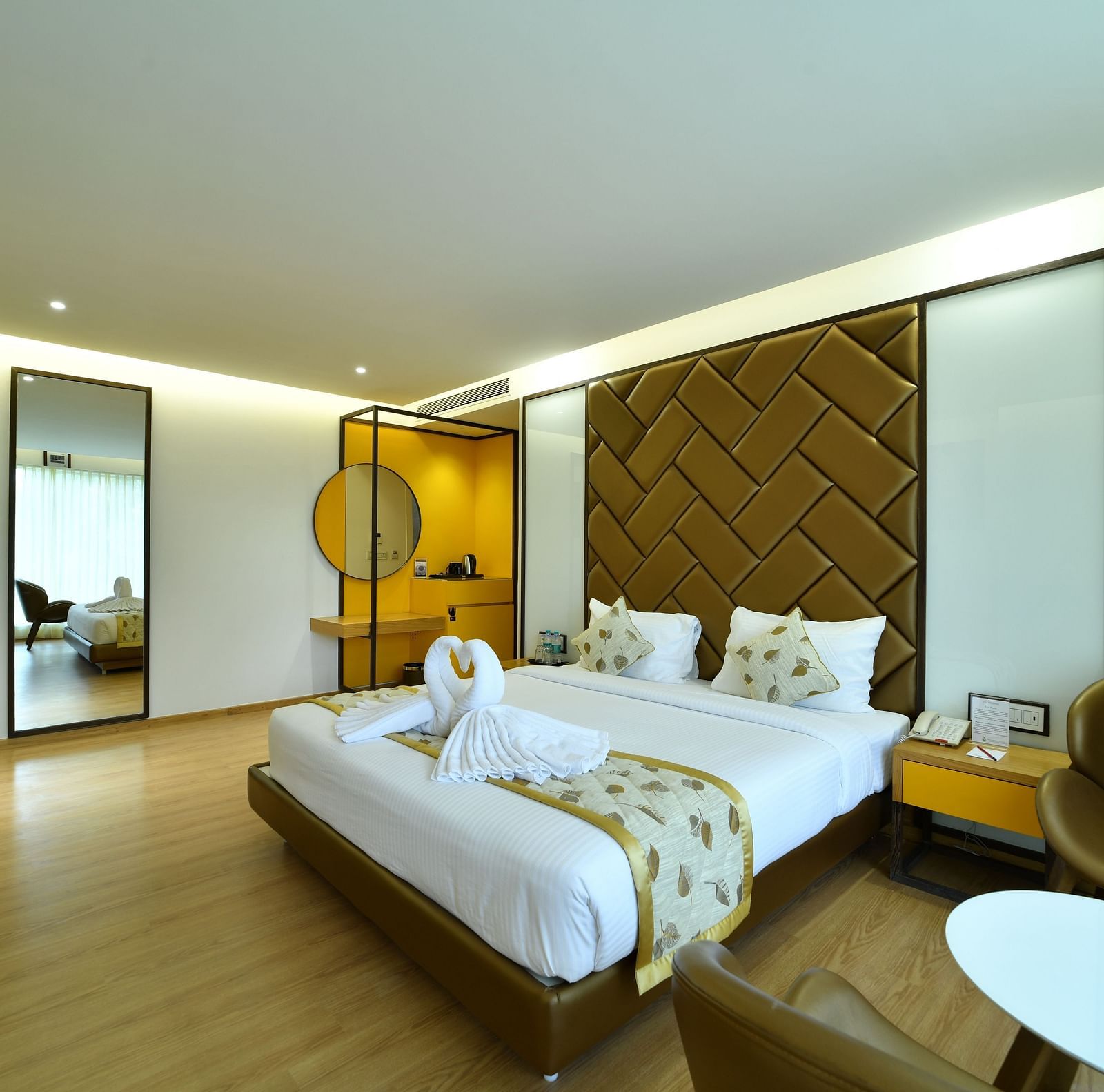 An image of a bedroom with a tea and coffee maker along with two chairs and a round table - The President Hotel, Kumara Park, Bangalore