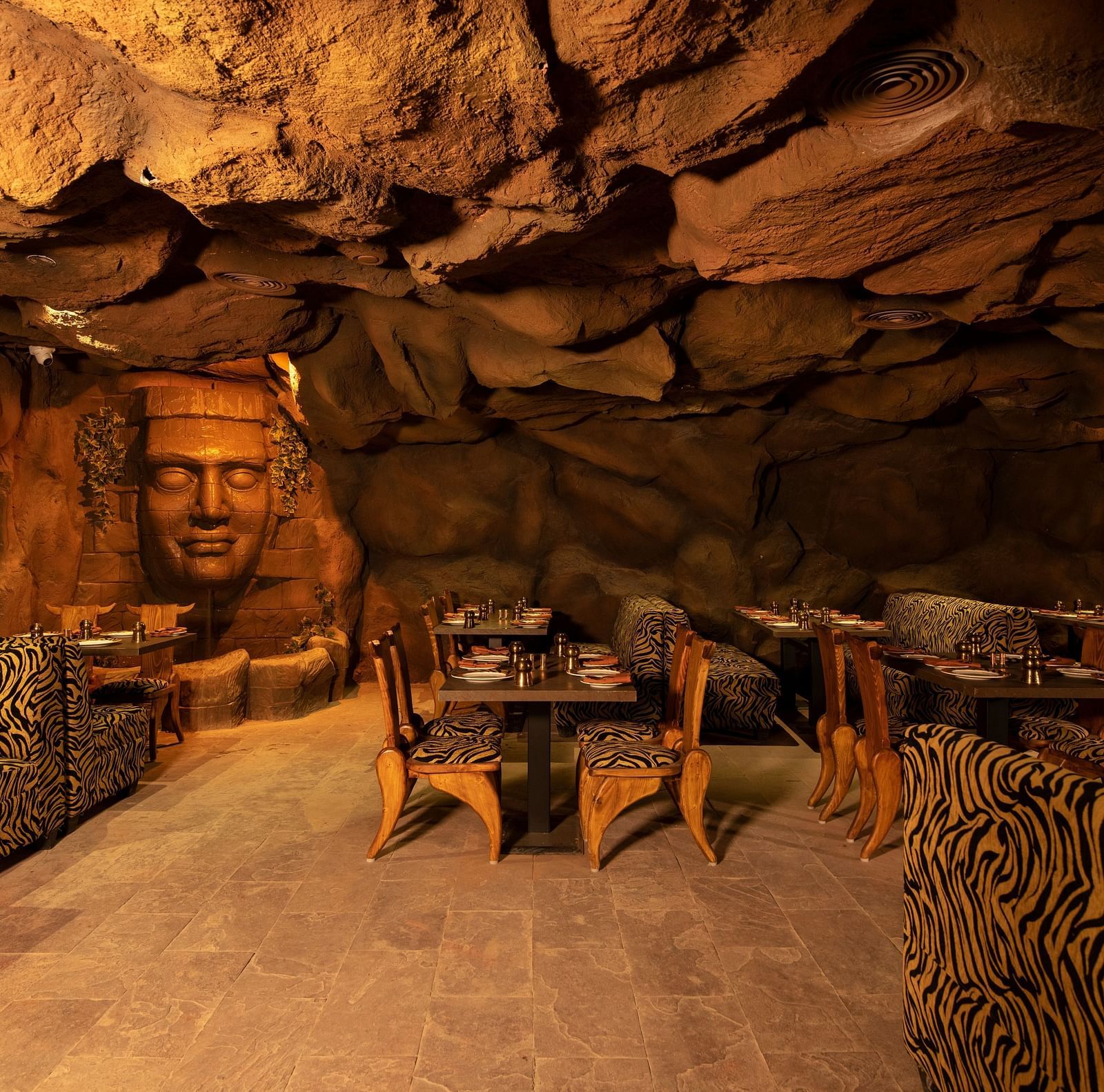 An image of a cave-themed restaurant with animal print-seats at The President Hotel, Kumara Park, Bangalore