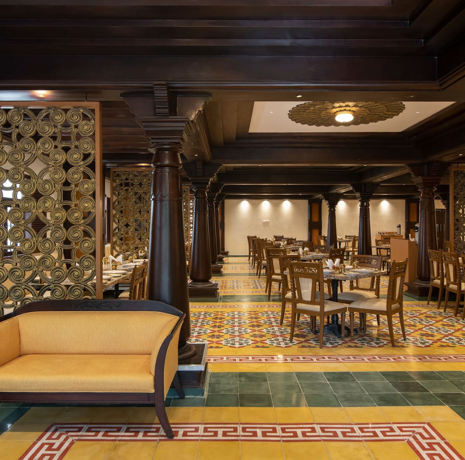 An image of side view of traditional-themed restaurant with seating arrangements - The President Hotel, Kumara Park, Bangalore