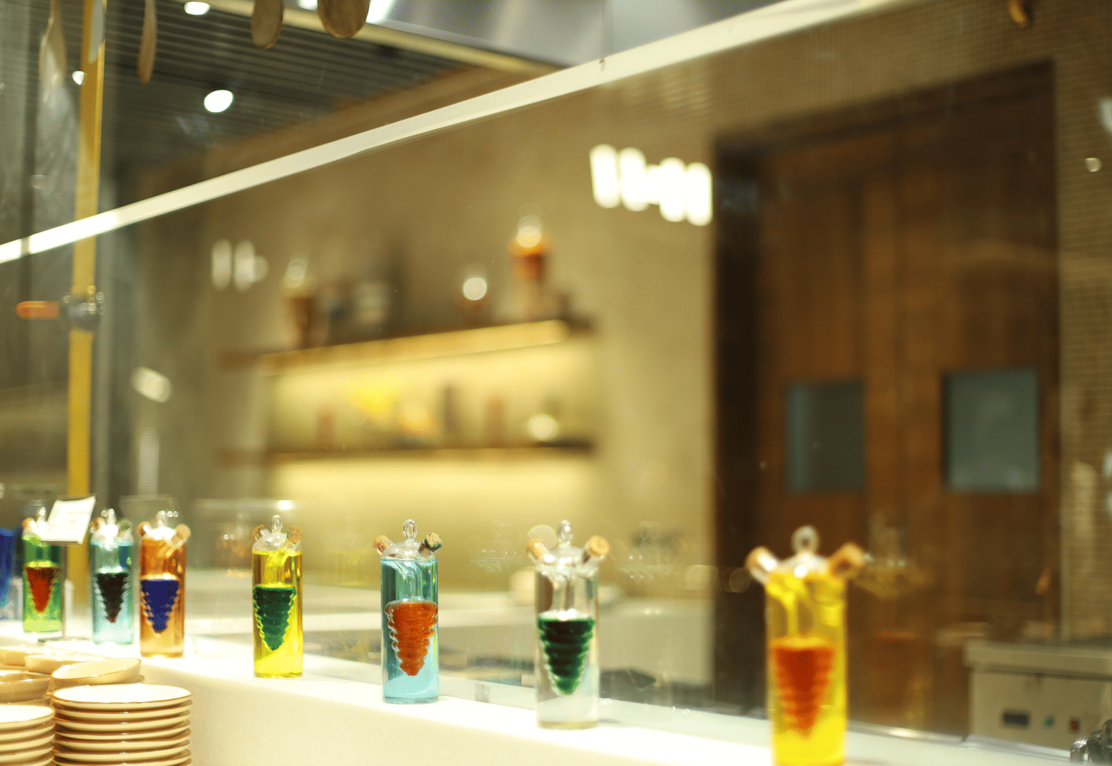 A vibrant display of colourful liquid art or cocktail ingredients behind glass at a bar in Pushkara Resort & Spa.