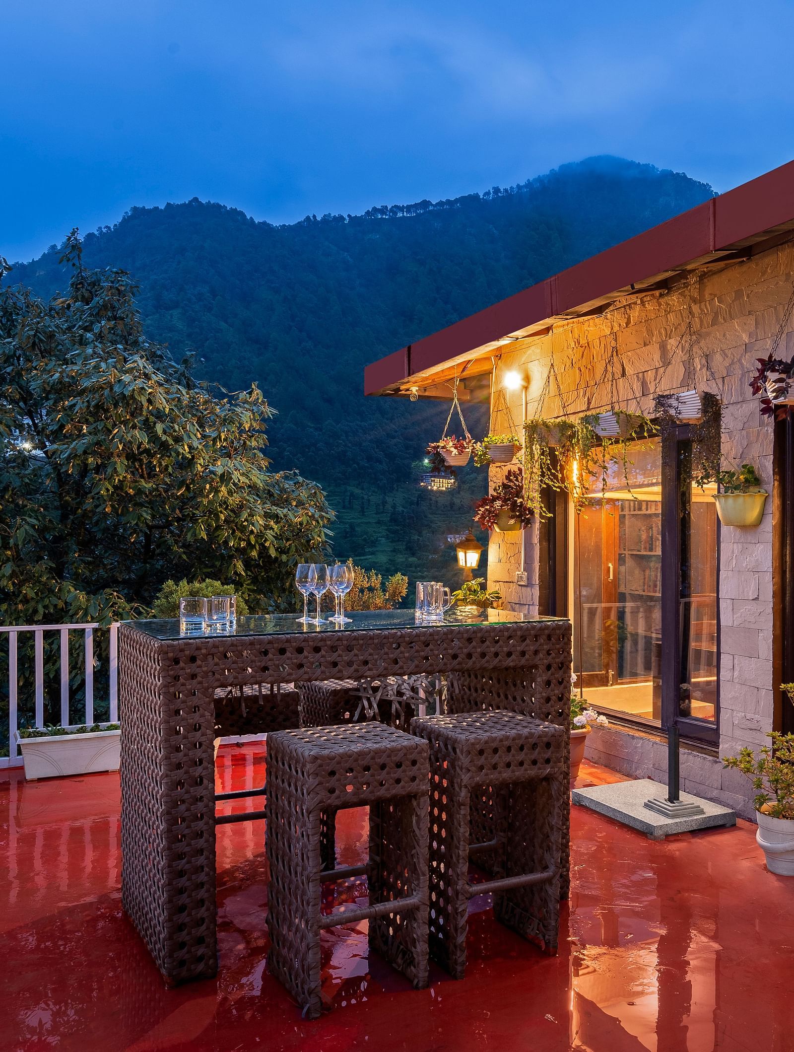 Cosy outdoor patio and a library, set against a mountain backdrop at dusk, at BluSalzz Collection - Suvaasa Resort, Ramgarh.