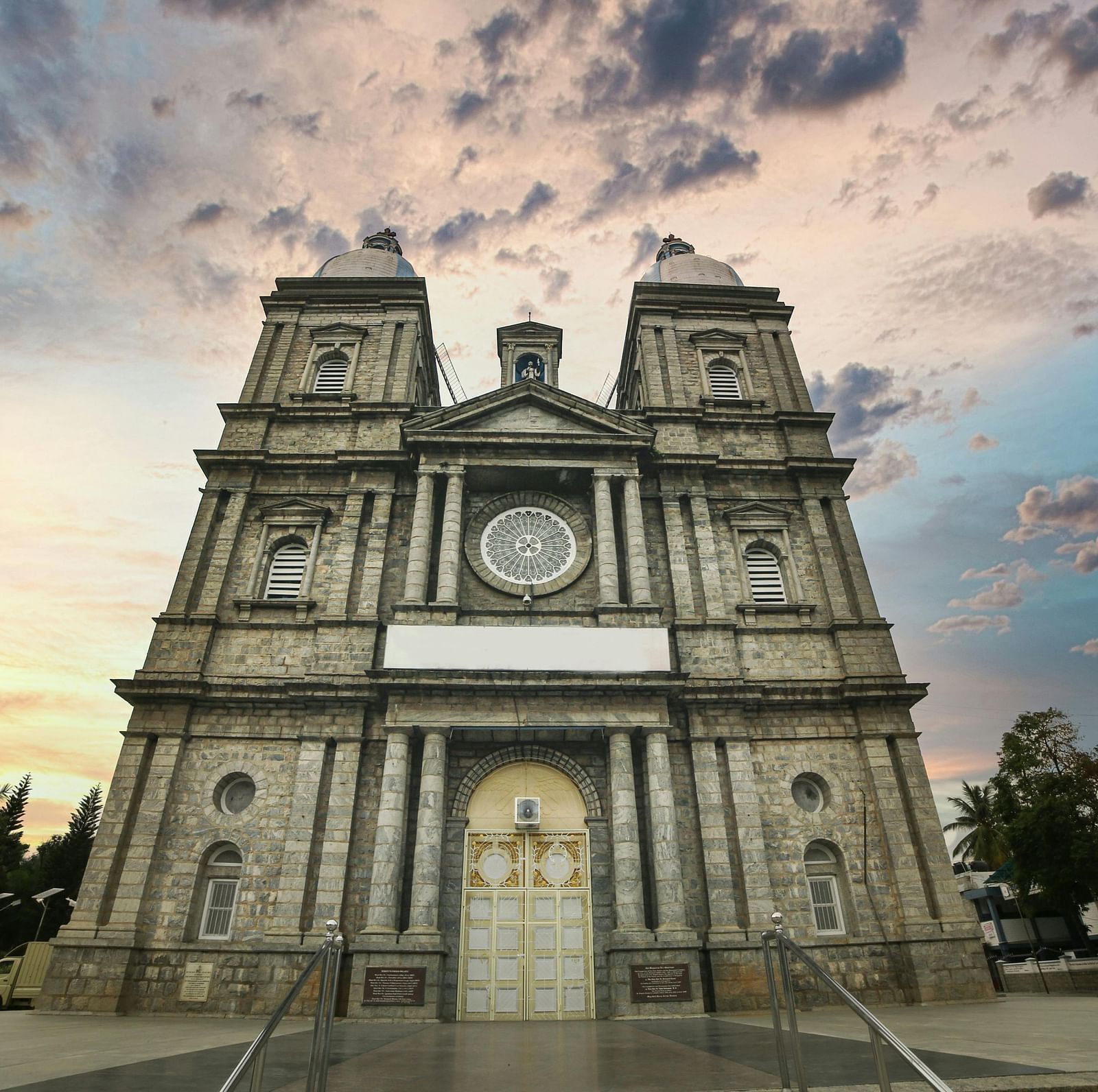 A grand church with Gothic architecture set against a dramatic, cloud-streaked sky.