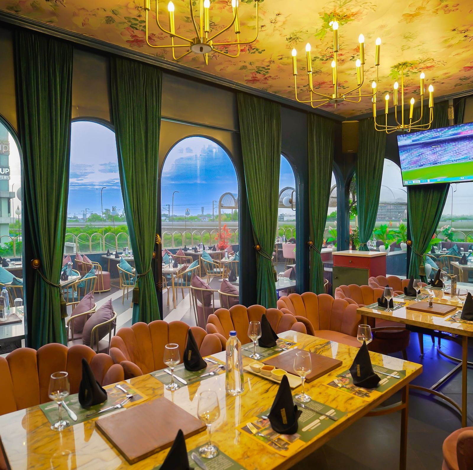 An image of lavish restaurant featuring tables and chairs with cultery, glasses, and hand towels - Themis Barbecue House