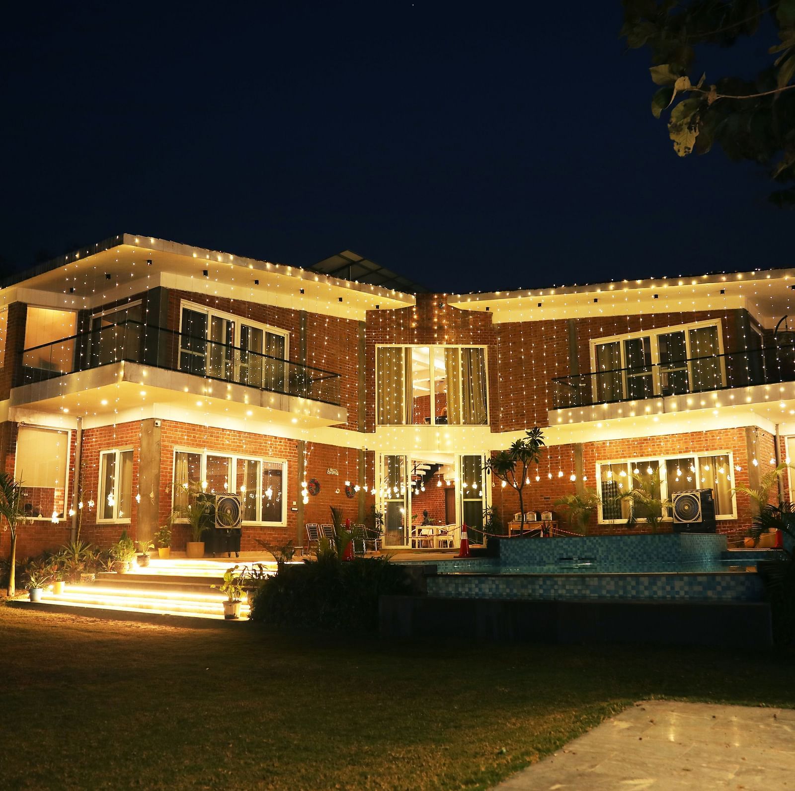 Night view of Tisya Farms decorated with warm yellow lights.