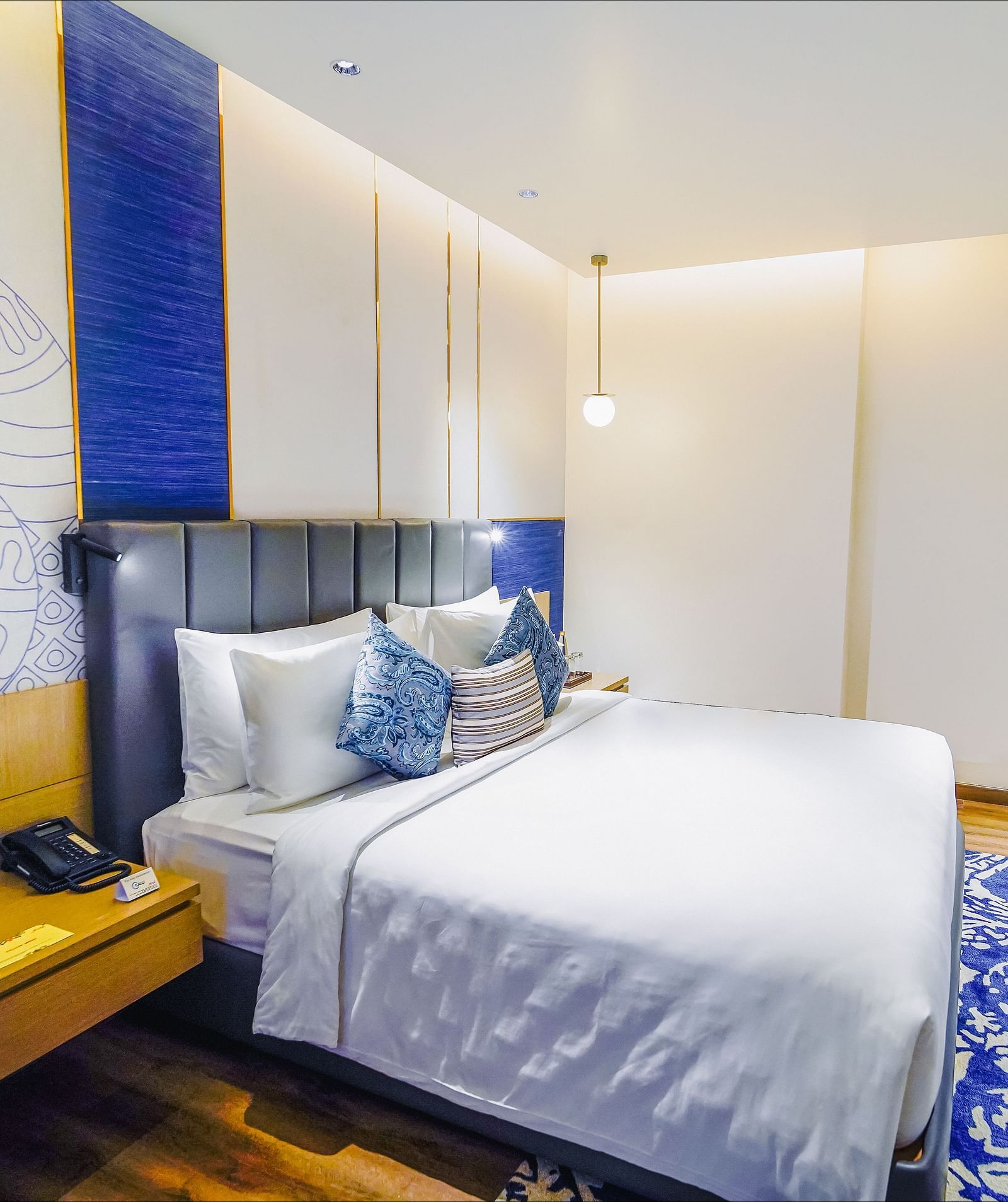 An image of our Junior Suite in Madurai with a night stand placed beside a plush bed