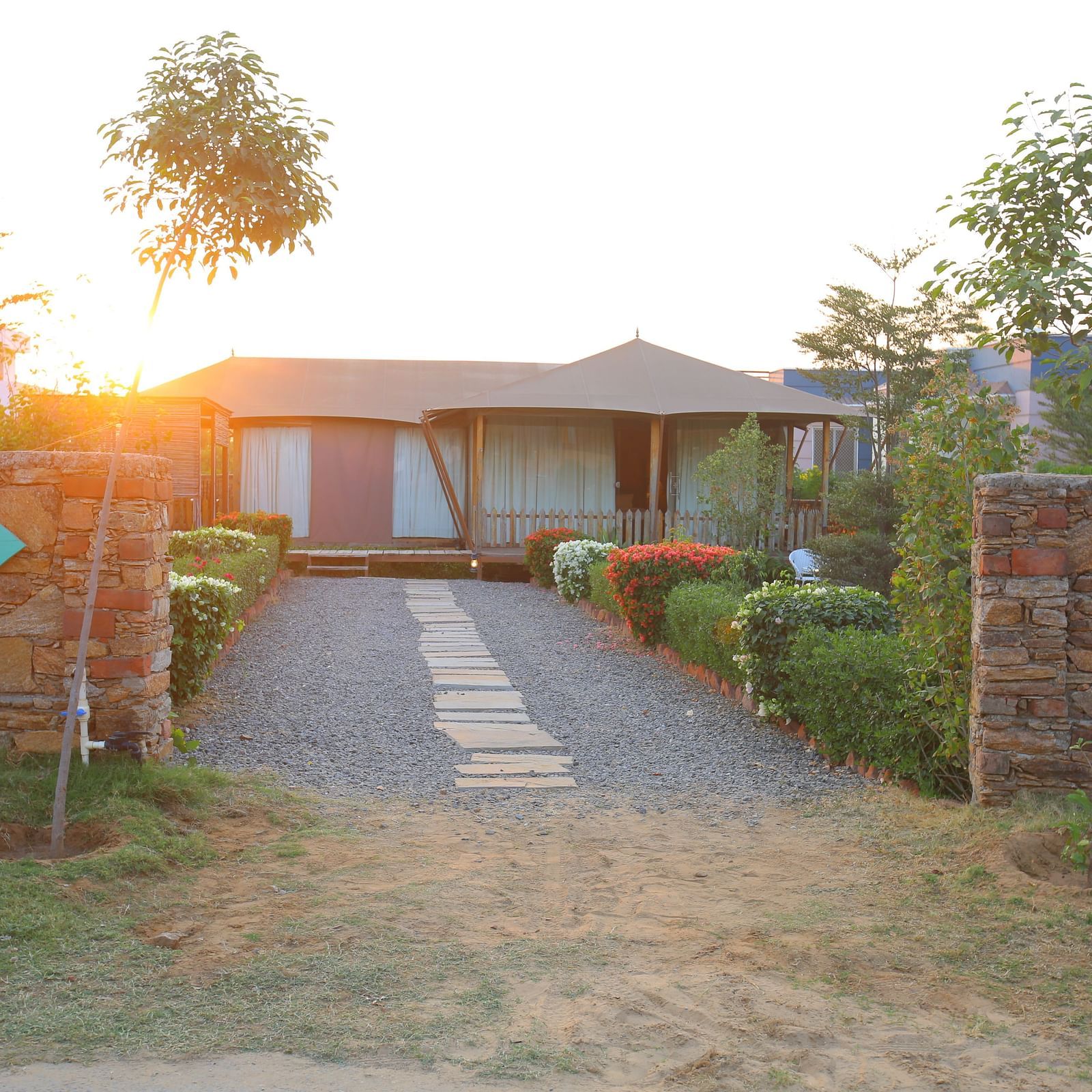 Front view of the Luxury Wooden Tent, with vibrant plants lining the pathway at Aanandam Resort & Spa