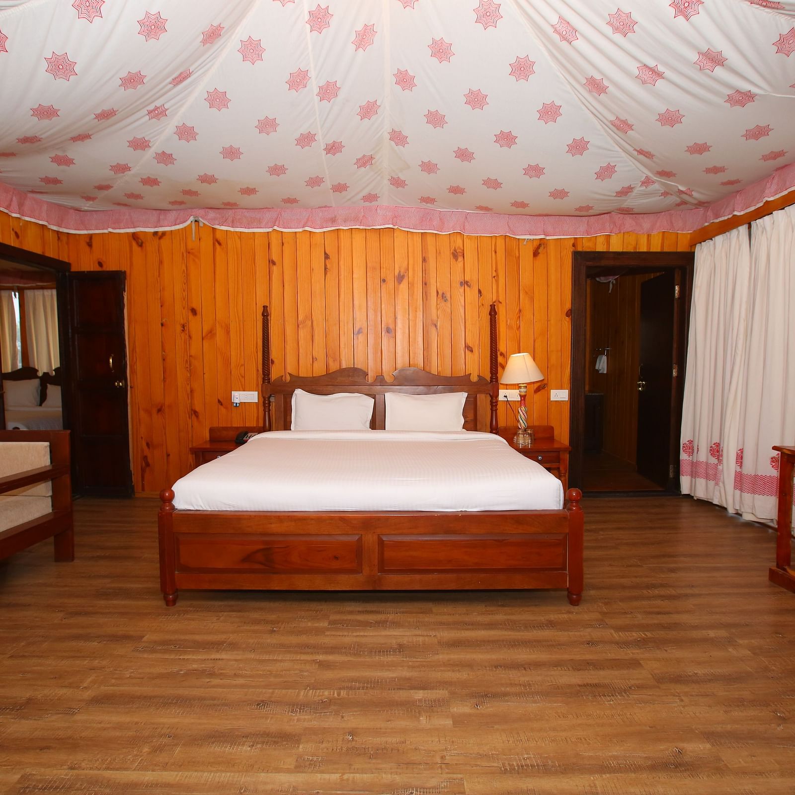 Spacious Luxury Wooden Tent with a king-sized bed and a corner cupboard at Aanandam Resort & Spa