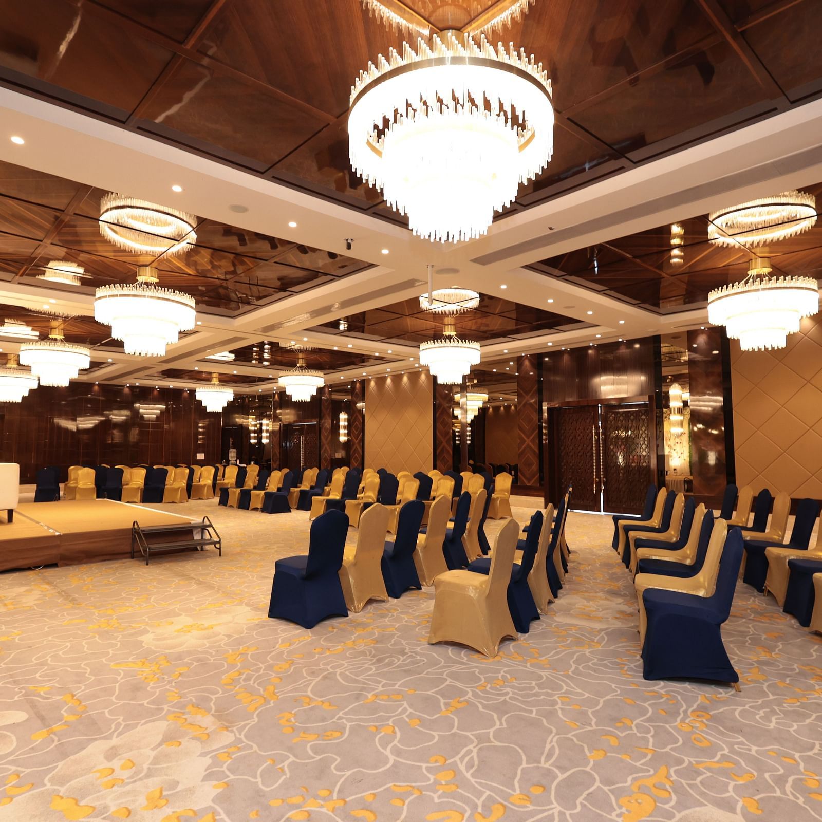 A side view of a banquet hall with chairs arranged around the stage area | Cenneys Gateway