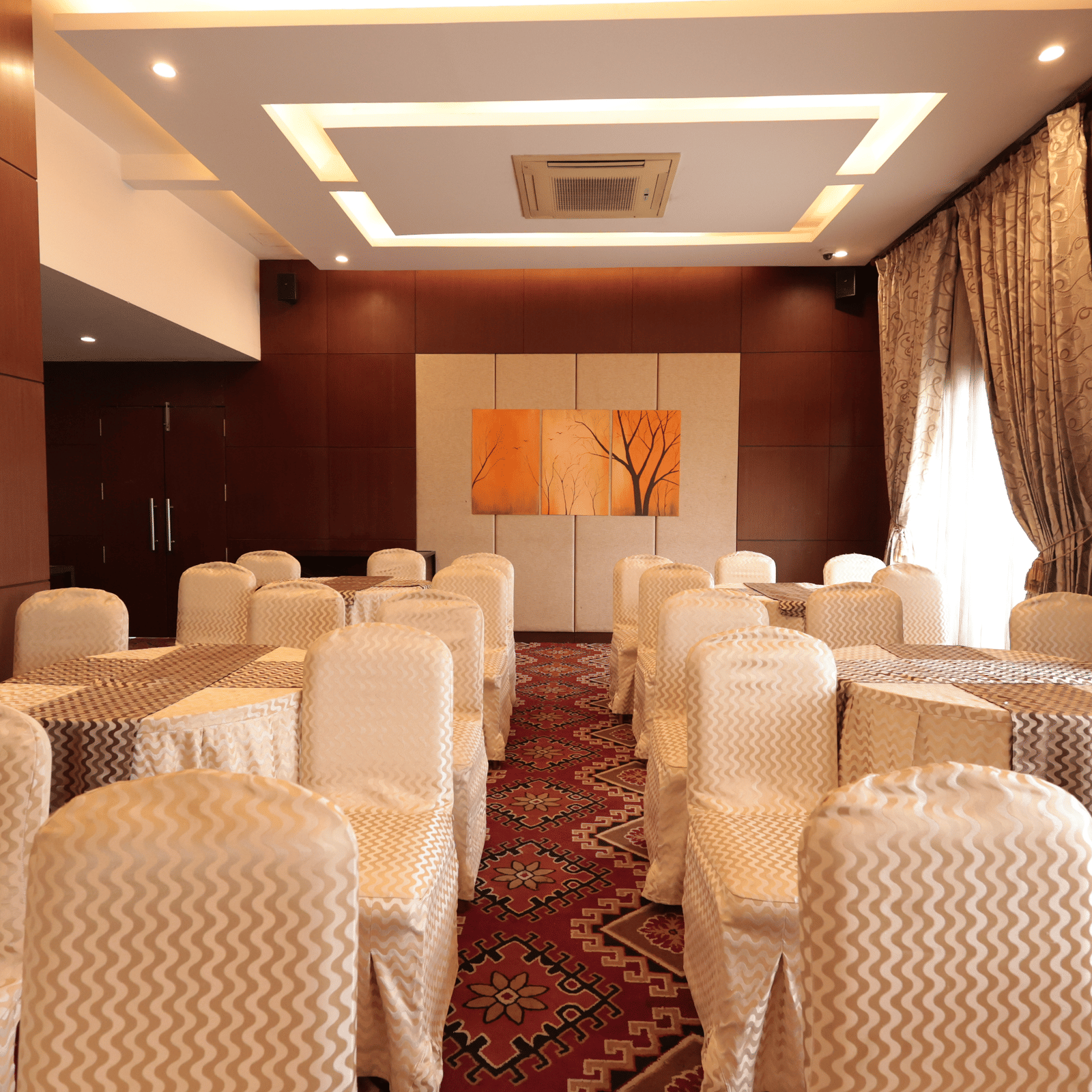 A small banquet hall with well-decorated chairs and curtains draped over the windows | Cenneys Gateway