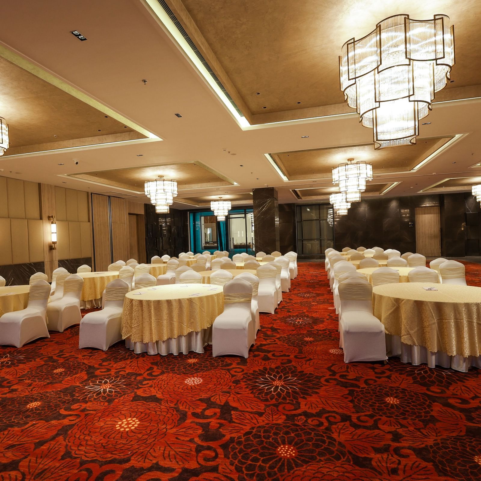 Lavish banquet space featuring a red patterned carpet and stylish lighting at Ramada by Wyndham Sonipat Murthal