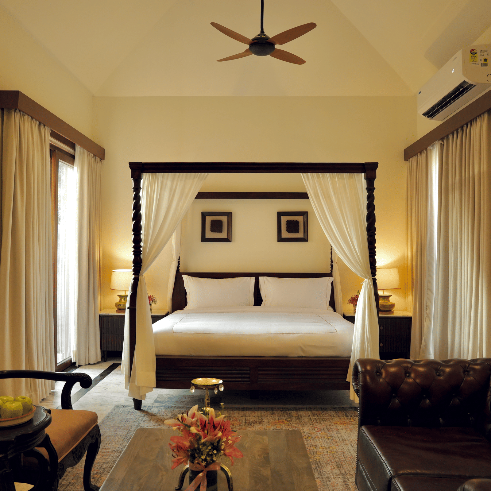 A room with a bed and a seating area in front at Surpura Bagh.