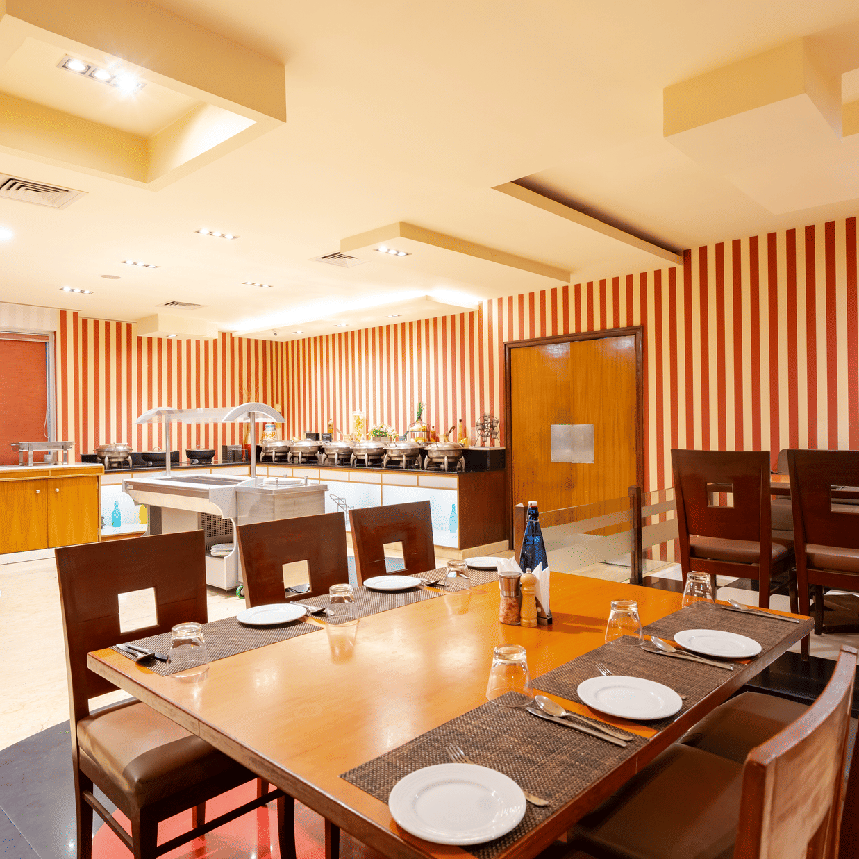 A dining space at MGM Mark Whitefield, featuring chairs, tables, and checkered wall.