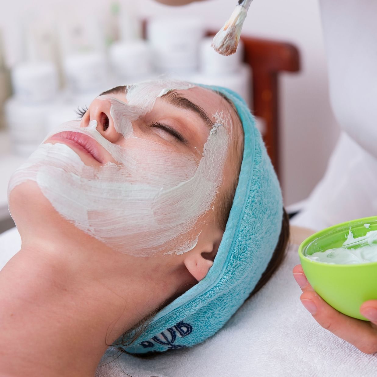 A person receives a facial treatment at a spa