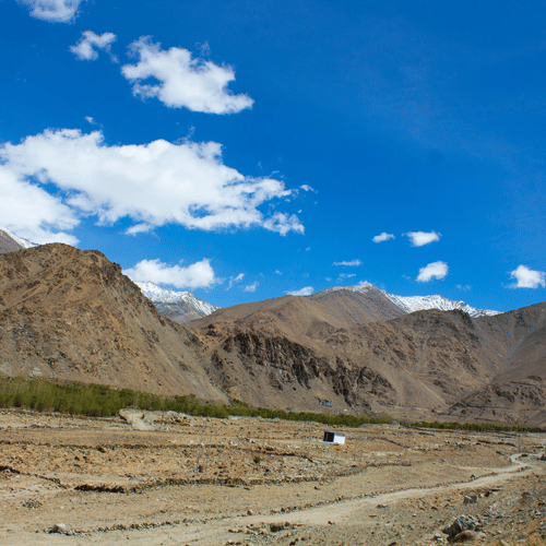 A rocky valley with a winding road along the side.
