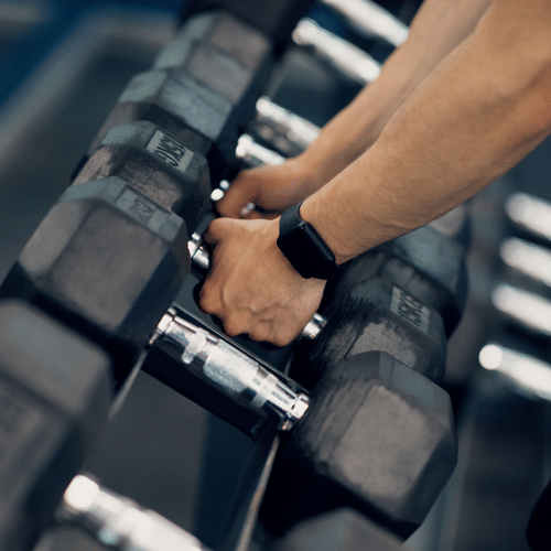 a Man picking up equipment in a gymnasium - La Maison Hotel, Doha