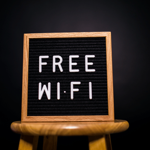 A free Wi-Fi sign displayed on a letter board placed on a wooden stool