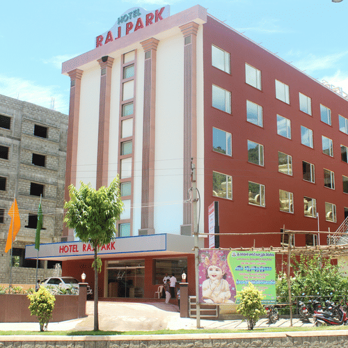 Facade of Raj Park Tirupati, showcasing a modern red-and-white exterior with a welcoming entrance in the heart of the city.