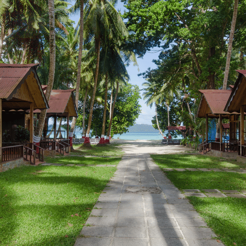 Pathway leading to beach with wooden cottages on either side