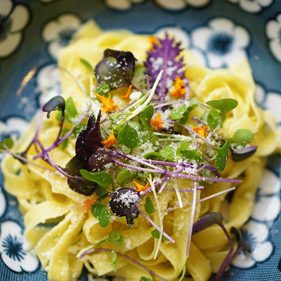 Close-up of a  with greens and herbs on a patterned plate.