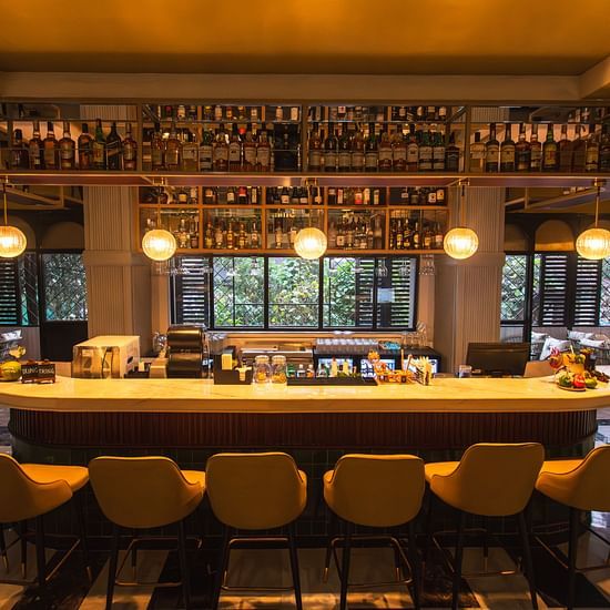 A well-stocked bar at Hotel Polo Towers with a variety of spirits and cocktails, inviting guests to relax and unwind.
