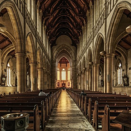 interior view of a cathedral with benches and an altar in view in the distance