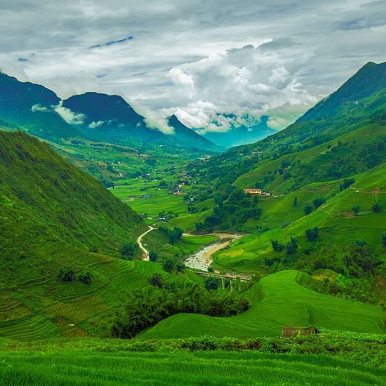Mountain peak with scenic lush green view and white clouds in the background