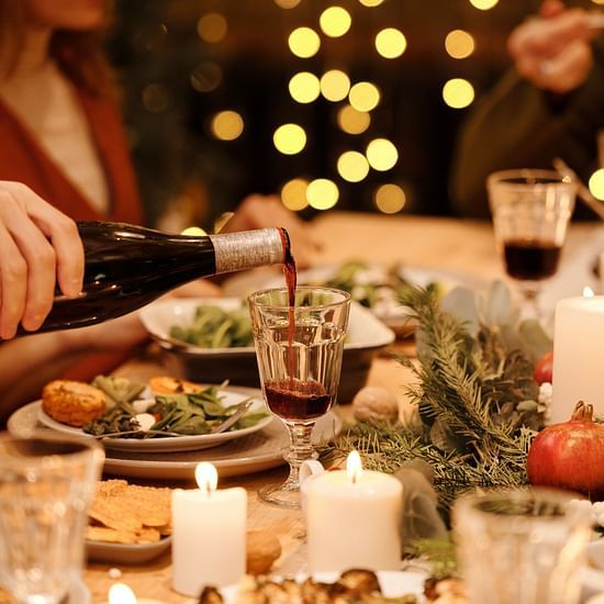 person pouring wine during a meal
