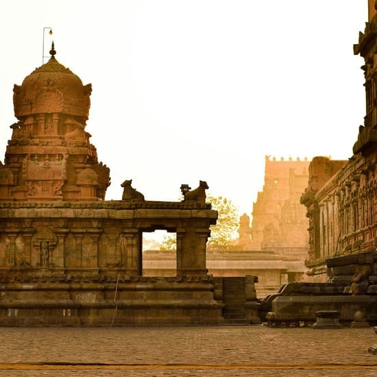 Ancient stone temple with intricate carvings, sculptures, and architecture at sunset.