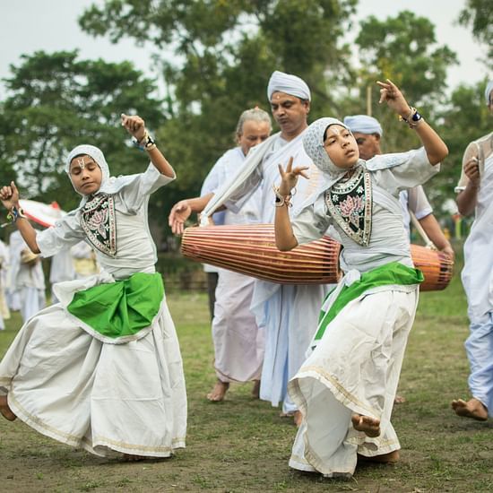 people dressed in native outfits while dancing and playing drums