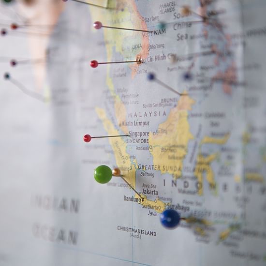 different coloured Pins on a map stuck to a wall