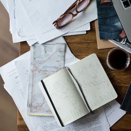A messy desk with a lot of items placed on it