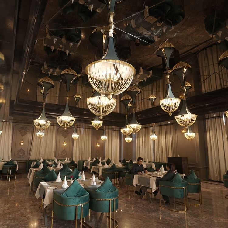 restaurant seating area with blue chairs and white table at Classic Sapphire by Ananta