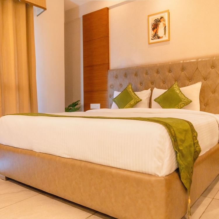 A large bed in a Deluxe Room at Montclair Ananta, Elite.