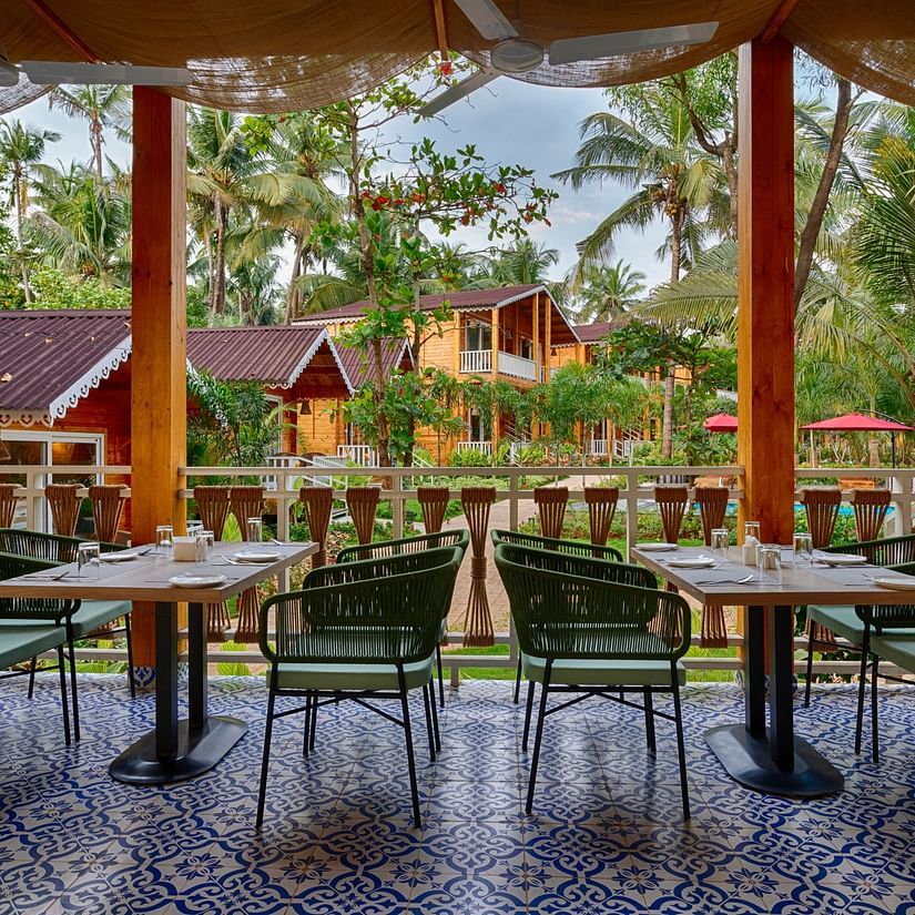seating arrangements in the restaurant with beams supporting the roof in view - Aralea Beach Resort by Stone Wood, Morjim