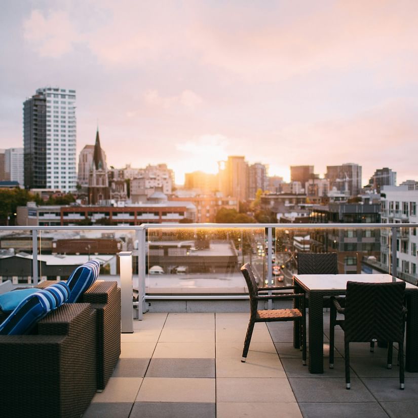 an overview of the seating arrangements inside a rooftop restaurant with the sun setting in the background