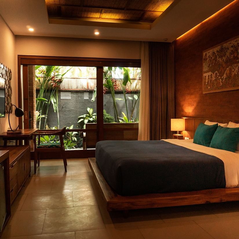 A hotel room with a double bed and a balcony