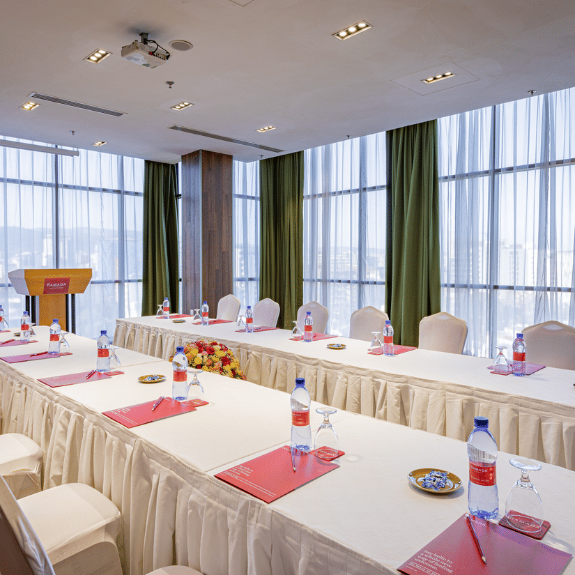 An overview of a meeting room with a parallel table set-up with water bottles and chairs in view at Ramada by Wyndham Addis, Addis Ababa.