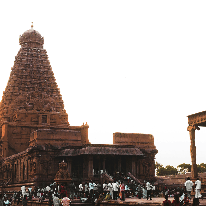 The historic Brihadeeswara Temple in Thanjavur, featuring its massive stone Vimana tower under a bright, hazy sky. It is one of the popular places to visit in Thanjavur for it's architecture.