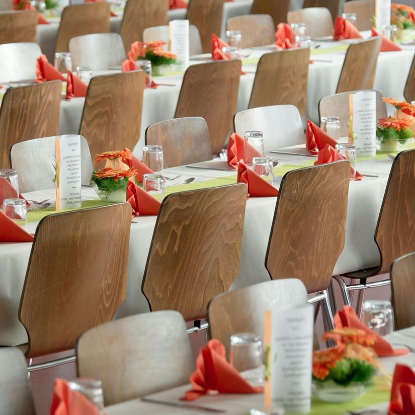 An array of chairs placed in front of a long tables in a conference hall