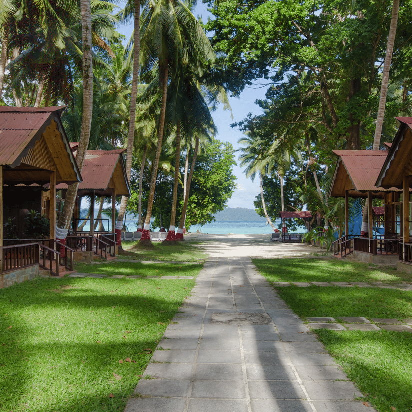 Pathway leading to beach with wooden cottages on either side