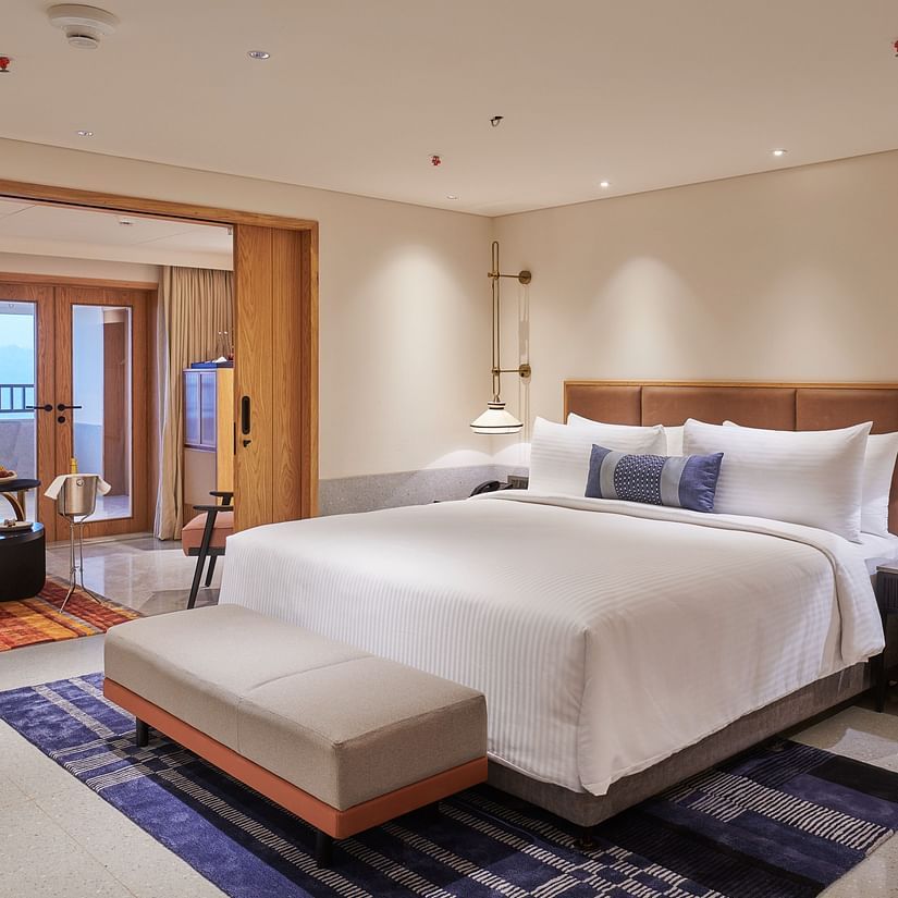  Image of a bedroom with a king size bed and a bed bench in front of it - The Dukes Retreat, Khandala