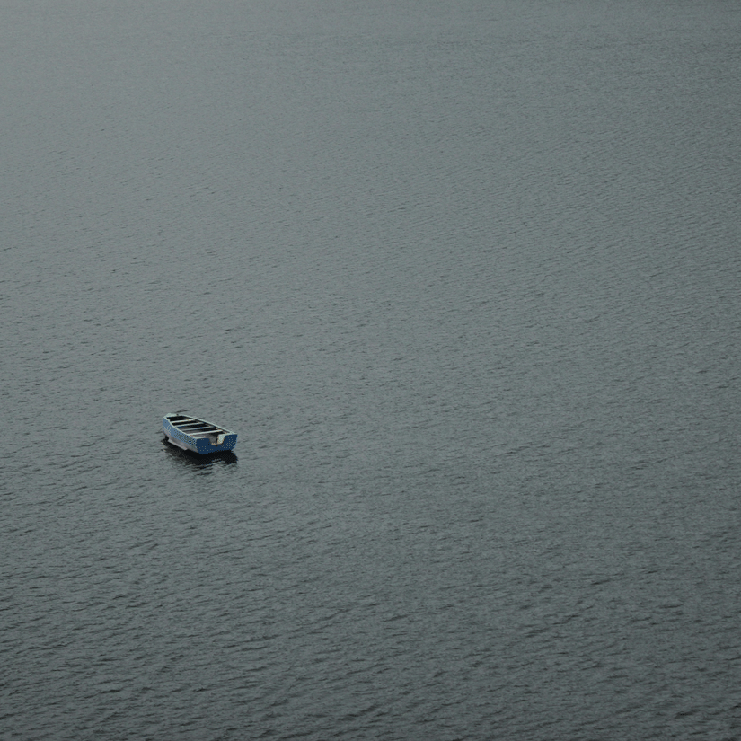 A view of a empty solitary boat flowing on Siliserh Lake with waves seen on the river body.