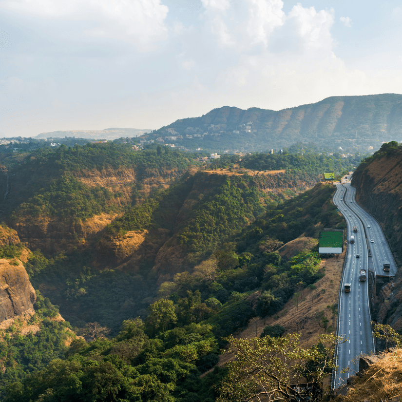 An overview of the Mumbai-Pune highway going through the Sahyadri Hills with mountains in the background.
