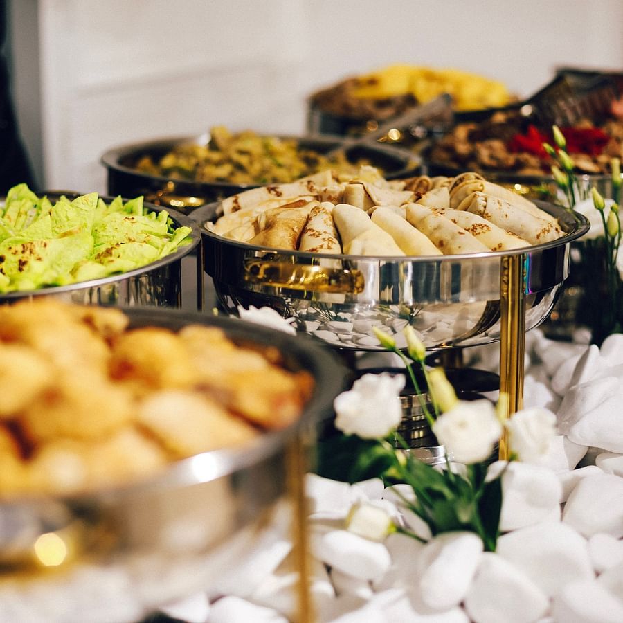 A buffet display with a variety of dishes in bowls and trays.