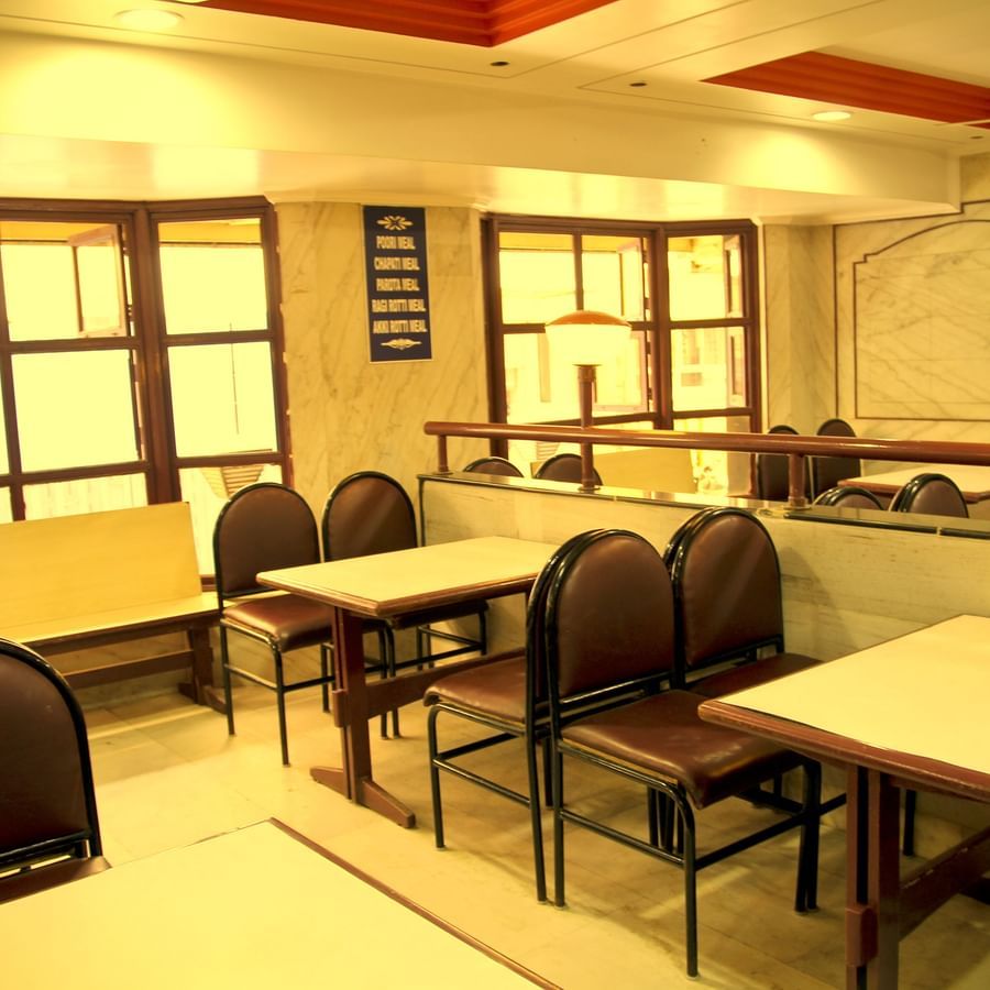 a view of a restaurant arrayed with plush seating arrangements at Hotel Swagath, Bangalore