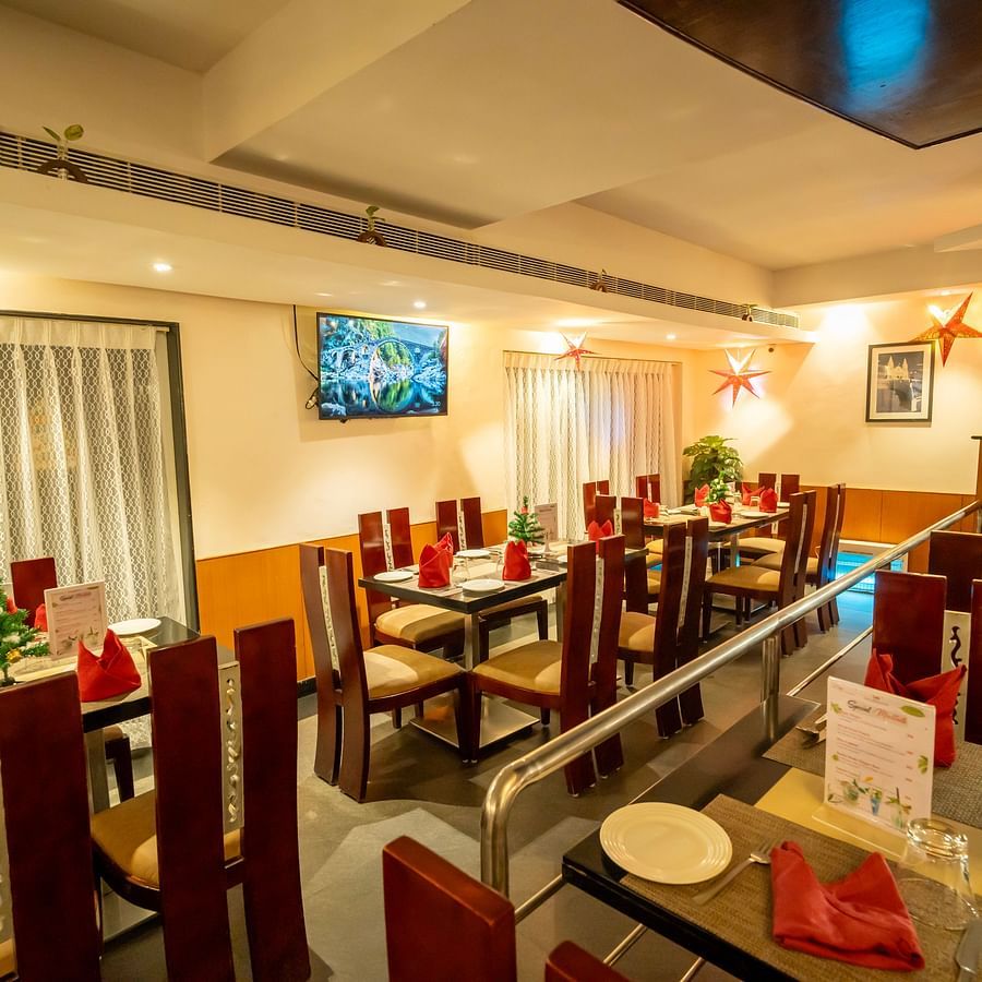 Image of a warm-lit restaurant with tables and chairs arranged