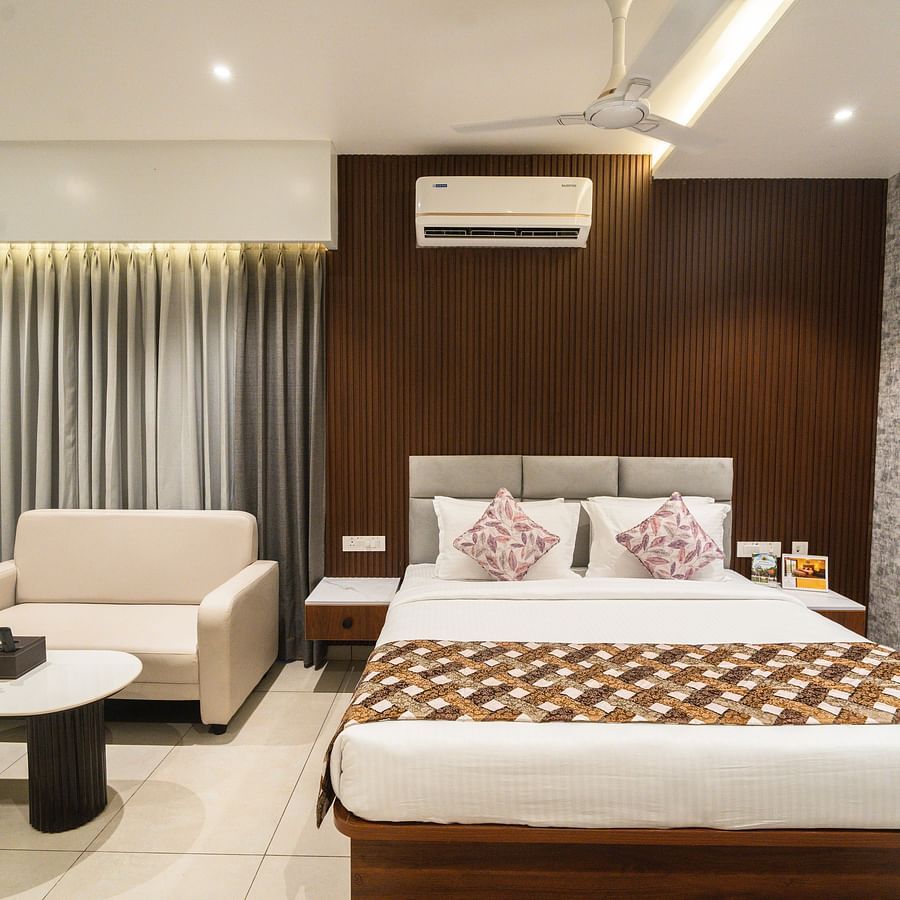 An image of a bedroom with a large bed, a sofa and a coffee table - MGM Whispering Meadows
