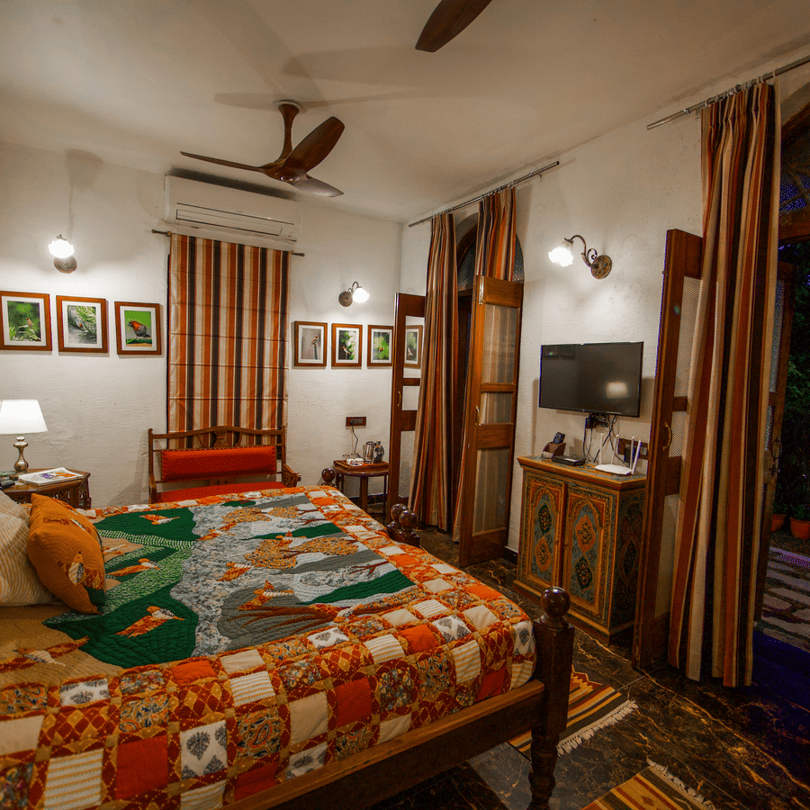 A bedroom with a patterned bedspread and pillows.